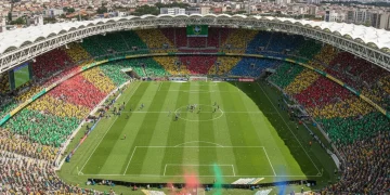 Estádio de futebol brasileiro com 30% da capacidade preenchida por torcedores vibrantes durante um jogo do Brasileirão.