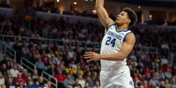 From College to Pro: The Journey of 2 Promising US Basketball Rookies in 2026 College basketball player soaring for a dunk, representing the transition to professional leagues.