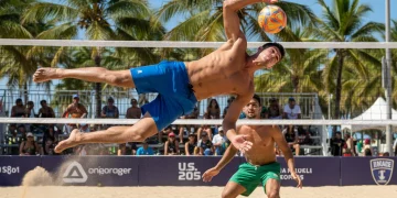 Dynamic footvolley defenders in action on a sunny beach court, showcasing agility and teamwork.
