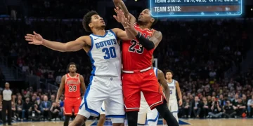 Two NBA players battling for a rebound, showcasing intense matchup dynamics.