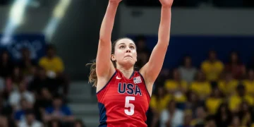 USA volleyball middle blocker executing a powerful block at the net.