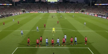 MLS player preparing to take a corner kick during a night game, showing tactical formation.